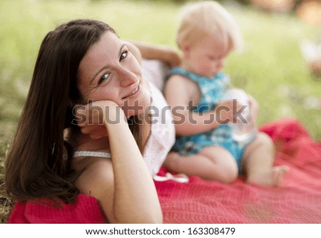 Happy young mother having fun with her son in nature