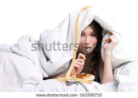 young woman eating cake under cover on white background Royalty-Free Stock Photo #163308710