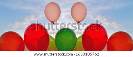 Panoramic background of colorful balloons over blue sky background and sun shining through clouds. decorative balloons on blue sky. concept of love and valentine, wedding. Outdoor Party decoration