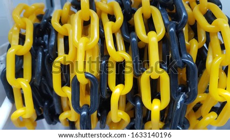 As a hanging roll to prepare for sale this is plastic chain yellow and black color