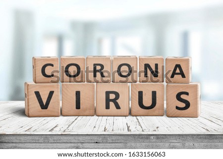 Corona virus alert message on a worn wooden desk i a bright environment