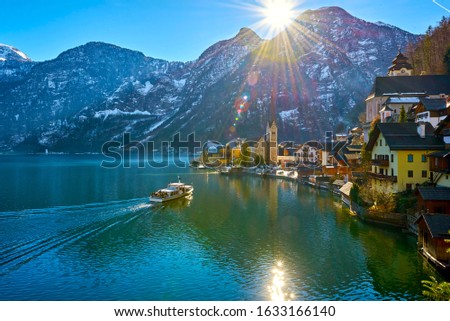 Beautiful winter landscape of Hallstatt mountain village with Hallstatter lake and boat in Alps. Austria.