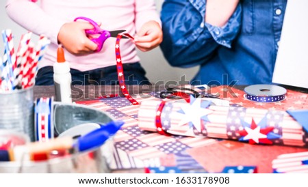 Step by step. Mother and daughter making paper firecrackers for July 4th celebration.