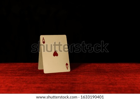 
cards house on the red poker table