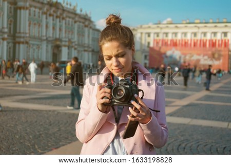 young woman trying to figure out how a camera works
