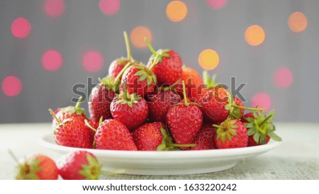 Strawberry stack in white dish over colorful sweet light bokeh background