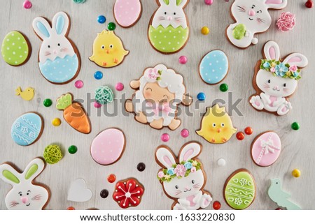 From above view of colorful ginger glazed cookies and chocolate balls isolated on white wooden background. Homemade lovely delicious pastry in shape of easter animals, eggs, flowers and carrots.
