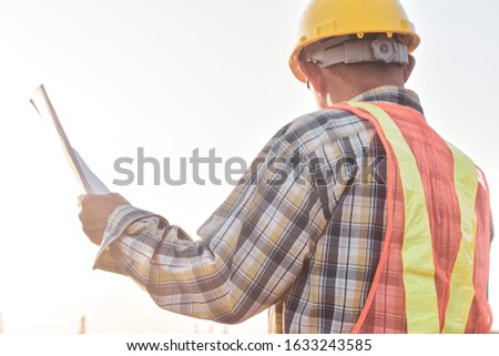 Senior Engineer Checking blueprint construction control management 