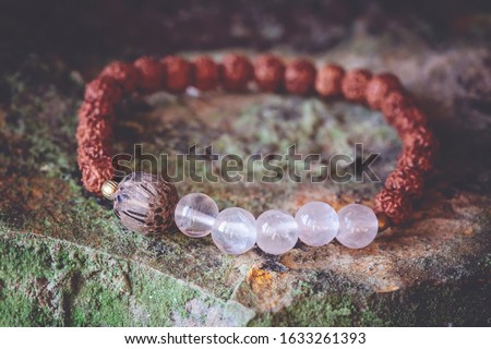 mineral stone beads and natural rudraksha seed beads bracelet on rocky background