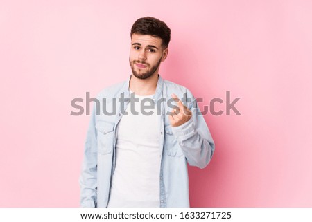 Young caucasian business man posing in a white background isolated pointing with finger at you as if inviting come closer.< mixto >