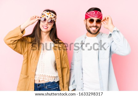 Young caucasian couple wearing a music festival clothes isolated excited keeping ok gesture on eye.