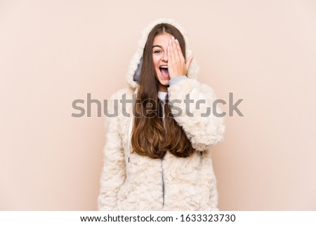 Young caucasian woman posing isolated having fun covering half of face with palm.