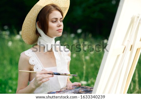 young woman draws a picture on canvas