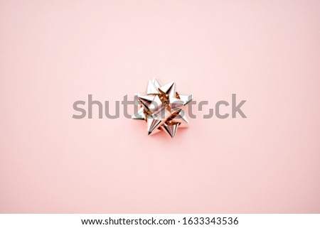 Pink gift bow on a pastel pink background. Top view, copy space.