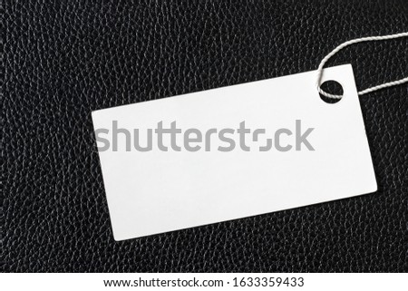 White label on a black leather. Abstract background for design. Art stylized baner or mock up with copy space for a text.