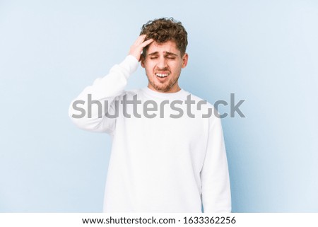 Young blond curly hair caucasian man isolated tired and very sleepy keeping hand on head.