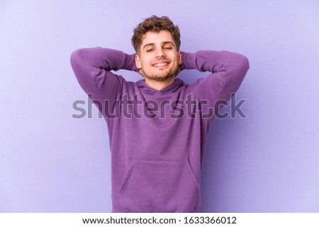 Young blond curly hair caucasian man isolated feeling confident, with hands behind the head.