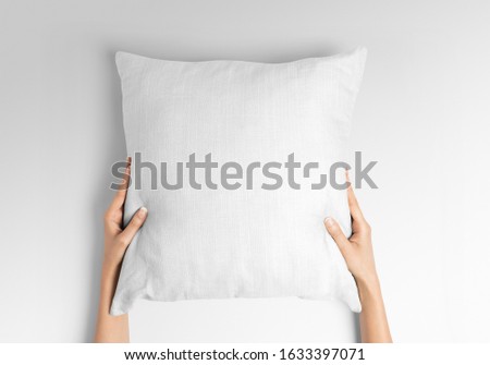 Blank white square pillow mockup holding with two hands by woman Royalty-Free Stock Photo #1633397071
