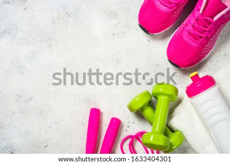 Sport equipment, workout concept for woman. Flat lay image on white background. Sneakers, dumbbell, jump rope, towel and bottle of water.