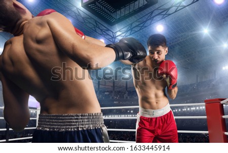 Two boxers are fighting on professional boxing ring.