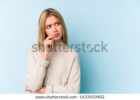 Young blonde caucasian woman isolated looking sideways with doubtful and skeptical expression.