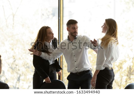 Two businesswomen having conflict at group meeting in boardroom, standing starting fight showing negative attitude colleague try to stop scuffle, confrontation, struggle for leadership at work concept Royalty-Free Stock Photo #1633494940