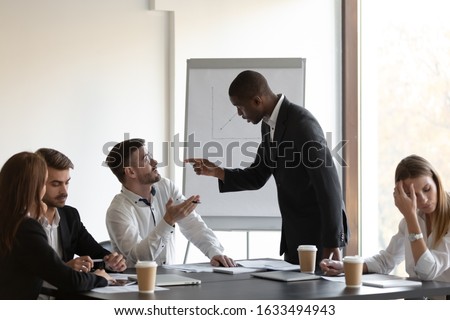 Multi-ethnic business partners having conflict accuse each other at group meeting in boardroom unpleasant situation caused by personal dislike, racial discrimination, struggle for leadership concept Royalty-Free Stock Photo #1633494943