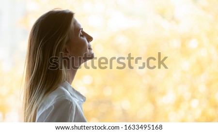 Side profile face inspired businesswoman breathing fresh air standing near window with autumn scenery view, concept of motivated successful business lady, woman enjoy free time closed eyes visualizing Royalty-Free Stock Photo #1633495168