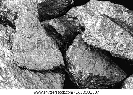 Manganese, manganese, or magnesium stone is a chemical element, it is in the manufacture of metal alloys. Silver colored ore, industrial use. Ore on black isolated background. Royalty-Free Stock Photo #1633501507