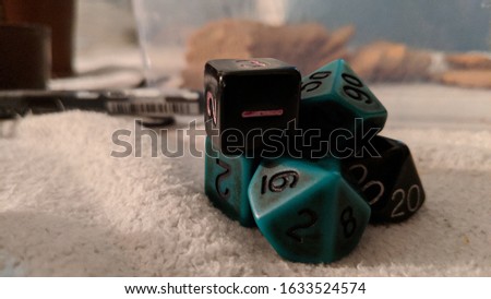 Nerdy pen and paper dice on a soft fabric