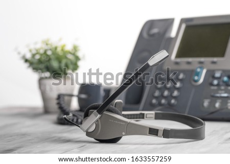 VOIP headset headphones telephone on office desk concept for communication, it support, call center and customer service help desk. Business center background, phone support service calls.