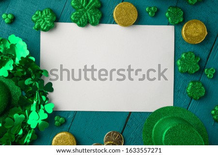 White postcard for design St. Patrick's Day celebration, on green wooden background, top view