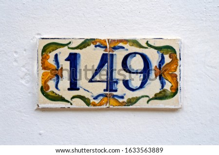 Street sign number 149 on a white wall                               