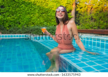 Portrait young asian woman relax happy smile around swimming pool in hotel resort