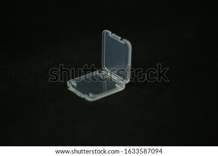 Transparent Sd memory card casing with black background photography.