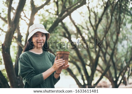  Image of an Asian woman In the concept of planting trees for the environment