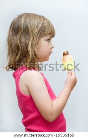 little, pretty girl licking fruity ice cream, on white background
