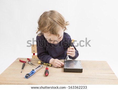 young child opening hard drive with screwdriver