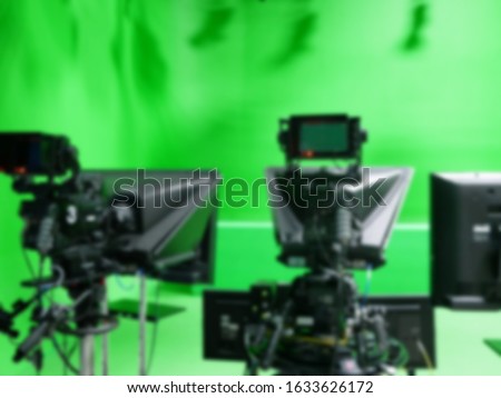 abstract blurred of broadcast camera in studio with greenscreen at TV station.