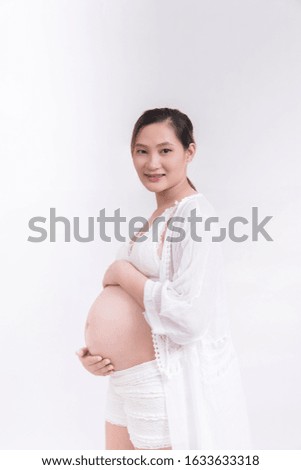 Pregnant Asian woman is touching her belly, unborn baby