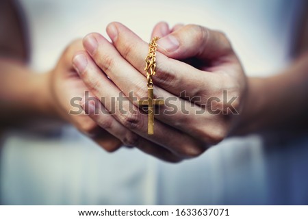 woman hands praying holding a beads rosary with Jesus Christ in the cross or Crucifix on black background.  Royalty-Free Stock Photo #1633637071