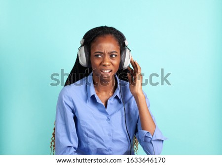 African Amreican young woman with retro wired head phones. Vintage Analog music concept.