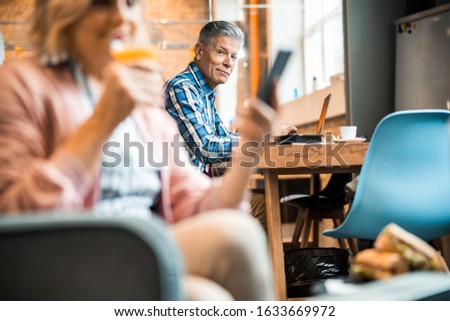 Mature male having lunch in cafe while looking at camera stock photo