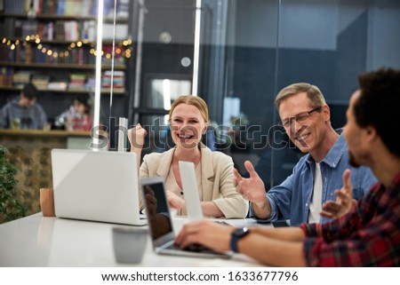 Business colleagues sitting at the table with laptops and communicating stock photo