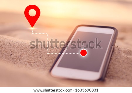 Smart phone on tropical sunset beach with gps navigator icon background. Technology business and travel holiday concept. Vintage tone filter effect color style.