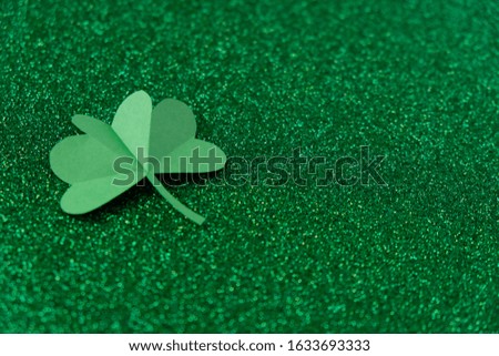St. Patrick's day, clover on a green shiny background