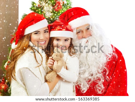 Picture of happy family celebrating New Year eve, little baby girl with parents enjoying winter holidays, father wearing red Santa Claus costume, Christmas magic, happiness and love concept