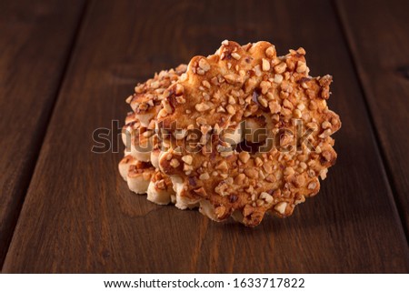 Round cookies with nuts on a wooden background
