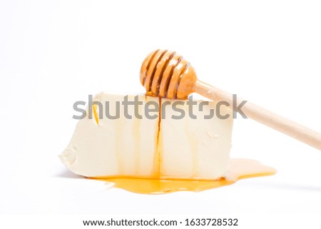 A picture of honey dipper with cheese for current food trend of honey cheese flavour concept.