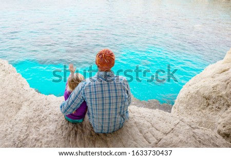 Father and little daughter on sea beach